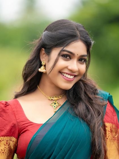 A classic portrait pose in a half saree. The model's bright smile and direct gaze make this a very engaging and personable shot.