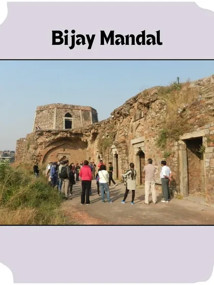 A group of walkers approaches the main structure of Bijay Mandal. The rough, rubble-built architecture is characteristic of the Tughlaq period, emphasizing function and scale.
