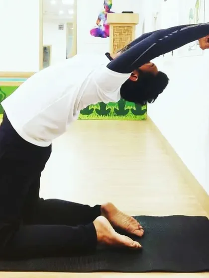 Here, I am using the wall to deepen Ustrasana (Camel Pose). This modification provides support while allowing for a greater opening in the chest and shoulders, showing how we can use our environment to enhance our practice.