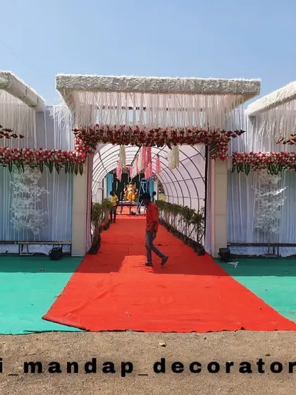 The entrance sets the tone for the entire event. I designed this grand entrance for a wedding, featuring multiple white structures decorated with fresh red roses and a bright red carpet to welcome guests in style.