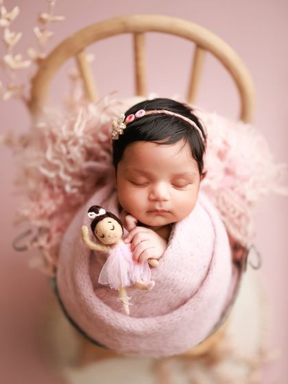 Another take on pretty in pink. This little ballerina, complete with a tiny doll, looks so sweet wrapped in a soft pink knit and nestled in a bucket chair.