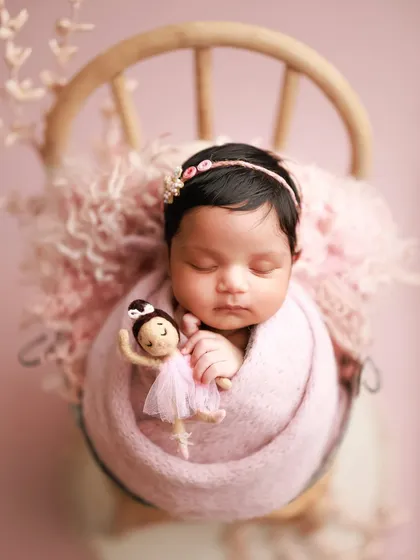 Another take on pretty in pink. This little ballerina, complete with a tiny doll, looks so sweet wrapped in a soft pink knit and nestled in a bucket chair.