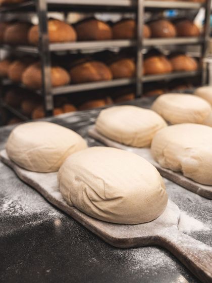 Dough loaves ready to be loaded into the oven. The surface is dusted with flour, ready to bake into a crusty, golden-brown exterior.