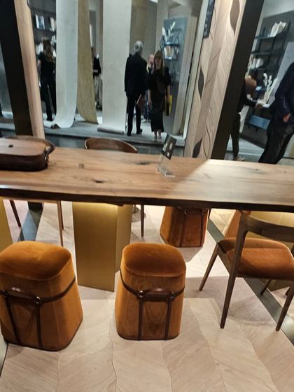 A showroom view of our geometric wood flooring, paired with a live-edge wooden table. We can create a cohesive look by using complementary wood finishes.