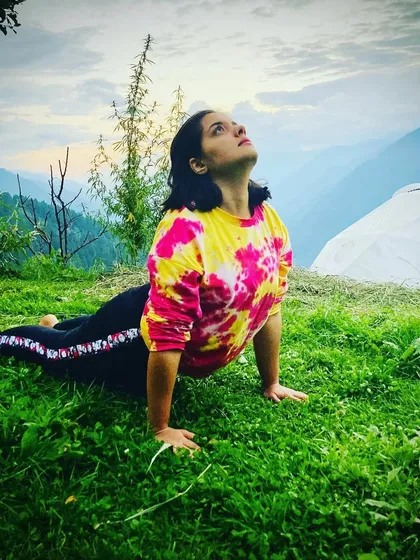 Here I am demonstrating Bhujangasana (Cobra Pose) in a beautiful outdoor setting. This pose is excellent for strengthening the spine and opening the chest, which helps counteract the rounded posture from holding a baby.