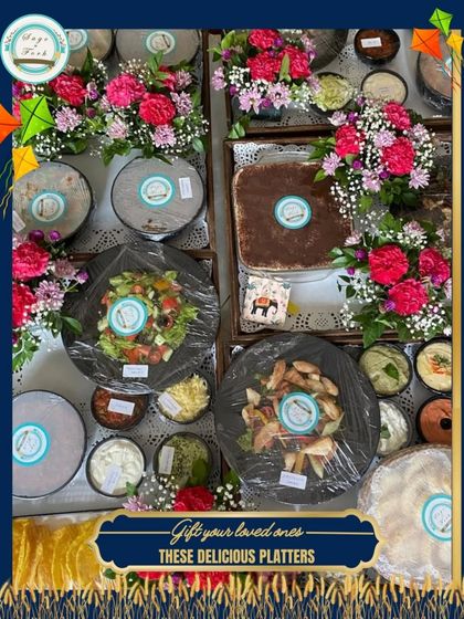 Looking for a thoughtful gift? Our curated vegetarian food platters are fresh, delicious, and made with love. This overhead shot shows a large order of beautifully arranged and packed platters ready for delivery.