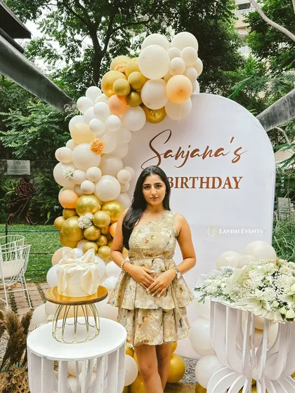 Celebrating a 21st birthday with a sophisticated gold and white balloon arch and natural jute accents.