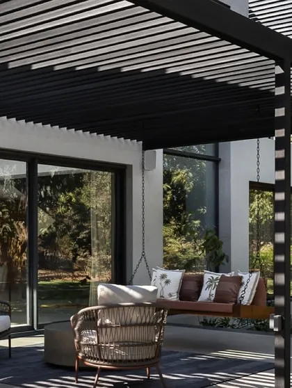 Another view of the outdoor lounge area, highlighting the interplay of light and shadow created by the overhead structure. This space serves as a natural extension of the home's interior living areas.