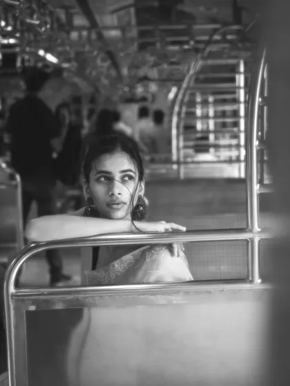 A black and white version of a classic train pose, emphasizing the lines and shapes of the train car and the model's contemplative expression.