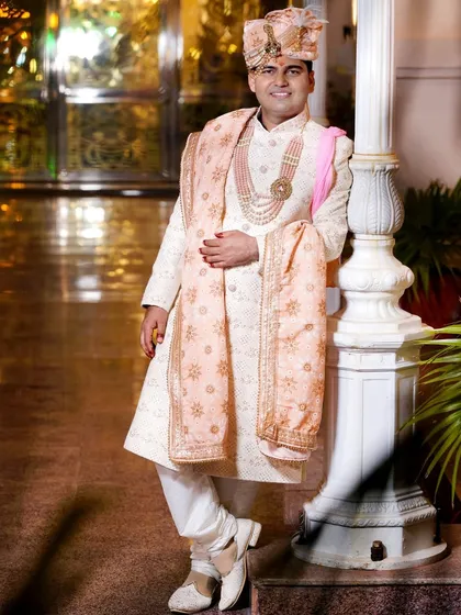 A classic pose of the groom in his elegant sherwani. The soft lighting and traditional attire make for a timeless portrait.