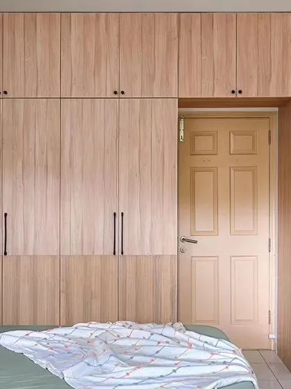 This wardrobe was designed to complement the muted palette of the master bedroom. It features light oak laminate, a fluted design on the bottom, and a unique ventilated cabinet for used clothes.