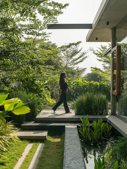 A pathway of floating stone slabs crosses a serene water body, leading you through the garden. This image captures the essence of the home's landscape design, which aims to create a resort-like feeling of tranquility.