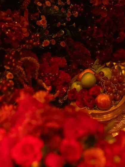 A close up of the rich textures in our all red decor. We used a variety of flowers and even incorporated fresh fruits like grapes and apples in golden bowls to add depth and a touch of classic still life beauty.