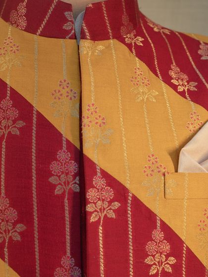 The traditional combination of red and yellow is reimagined in this bandhgala jacket with intricate brocade work, perfect for festive celebrations.