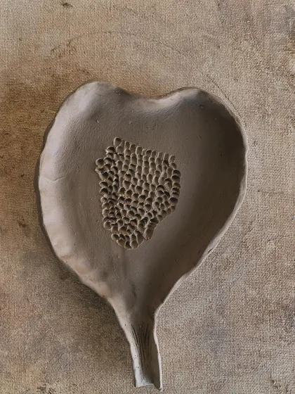 A leaf-shaped dish with a textured center, waiting to be glazed. The natural form is so beautiful.