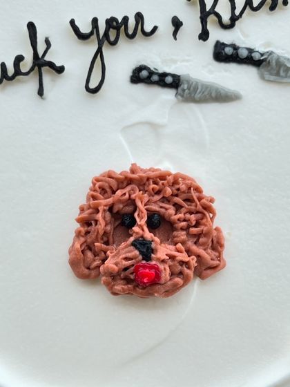 A close-up of the intricate piping work required to create the texture of a poodle's fur on a custom bento cake.