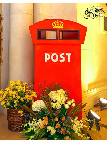 A classic red British postbox prop, adorned with a beautiful floral arrangement, adds an authentic touch to the 'Teddy in London' theme.