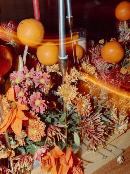 A close-up of a centerpiece featuring oranges and flowers, with a creative light trail effect.
