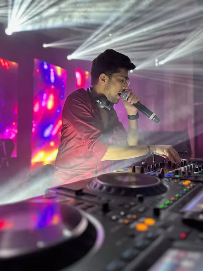 On the mic, connecting with the crowd. This shot captures me interacting with the audience while mixing, with beams of light creating a starburst effect all around me.