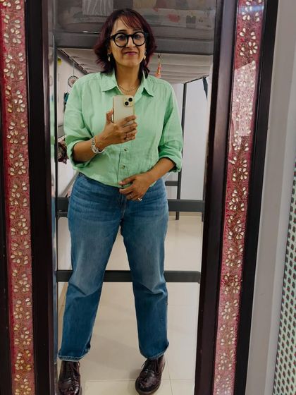 A mirror selfie showing a casual linen shirt and jeans look. Sometimes, simplicity is the most chic.