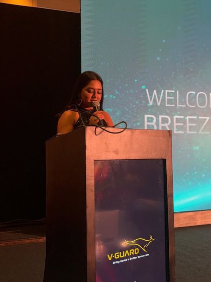 At the podium during the V-Guard event. This is my element, where I connect with the audience and guide them through the event's agenda.