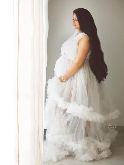 Using the soft light from the studio window, we can create serene and thoughtful portraits. This image captures a moment of peaceful connection between a mother and her unborn baby.