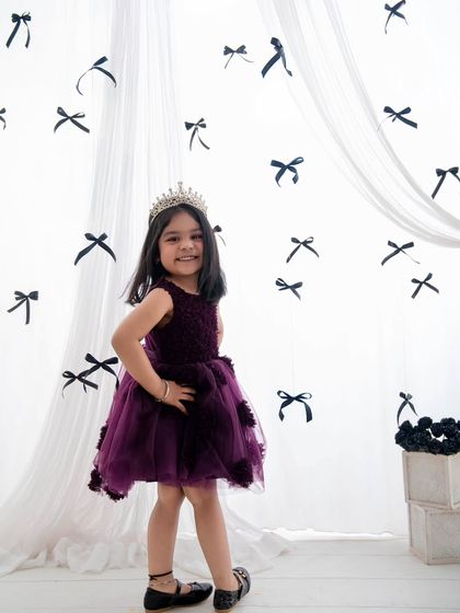 Everything white, pretty, and nice. This little princess, in her purple dress and crown, is ready for her fourth birthday photos.