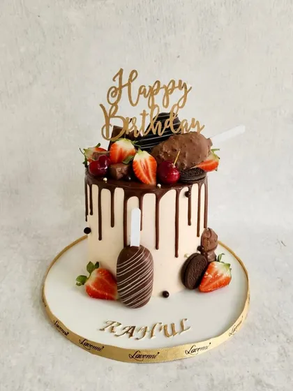 A simple and elegant drip cake. The chocolate drip is topped with fresh strawberries, cherries, and chocolate-covered cakesicles.