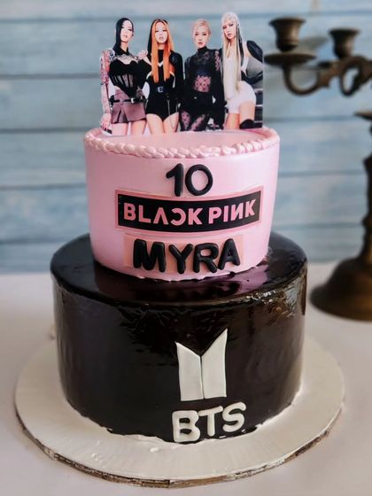 For the K-Pop fan, this two-tier cake combines Blackpink and BTS themes. The bottom tier is a rich chocolate, while the top is a fun pink design.