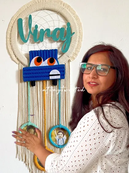 This custom nameplate for 'Vinay' combines a dreamcatcher design with a cute macramé car and three mini photo frames. It's a wonderful way to display precious memories right in your child's room.