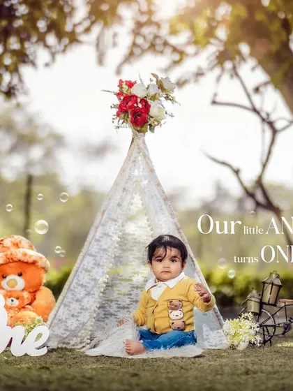 A beautiful outdoor first birthday setup featuring a lace teepee, a teddy bear, and bubbles. We create these magical scenes to make your child's milestone truly special.