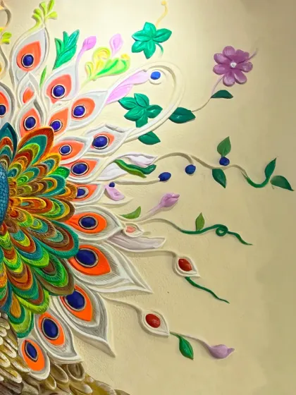 A close-up of the peacock's tail, showing the intricate, sculpted feathers and floral elements.