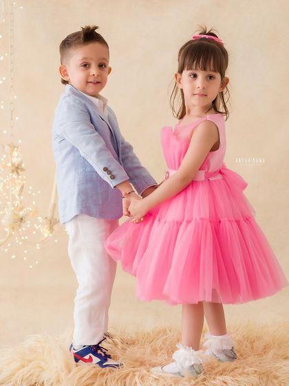 Siblings holding hands in a classic pose. This portrait captures their connection and the innocence of their bond.