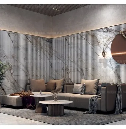 The corner sofa is positioned to take advantage of the feature wall, which combines fluted panels and a large marble slab, all highlighted by warm, indirect lighting.