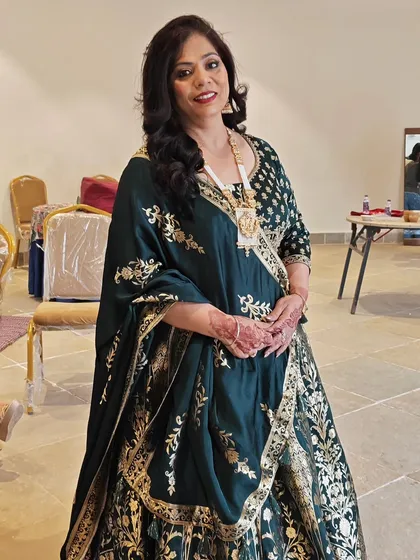 Styling the groom's bua for a destination wedding. We chose a classic hairstyle with side-swept waves that beautifully complemented her elegant green and gold outfit.