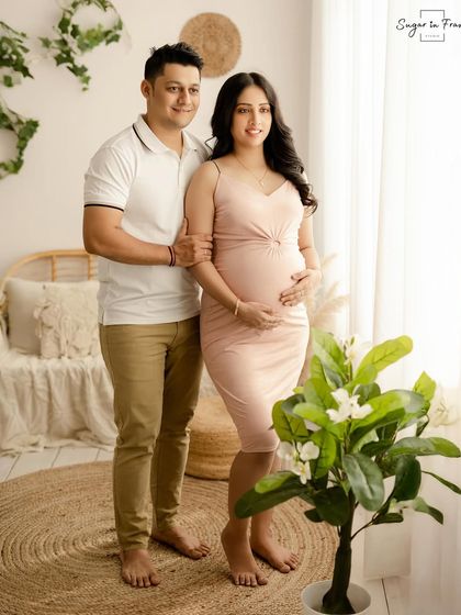 A bright and happy maternity portrait of the couple standing in our cozy studio. The greenery and natural textures add to the fresh and airy feel of the photo.