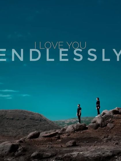 A dramatic landscape shot with the couple as a small part of the vast scenery, overlaid with the words "I Love You Endlessly." It’s a powerful and cinematic declaration of love.