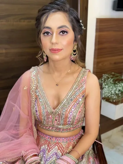 Ready for her engagement in a beautiful pastel lehenga. The makeup features soft pink tones on the eyes and cheeks, creating a fresh and youthful glow.