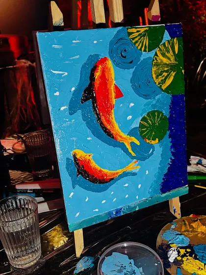 A finished koi fish painting glowing under the lights of the brewery, showing how art can liven up any space.