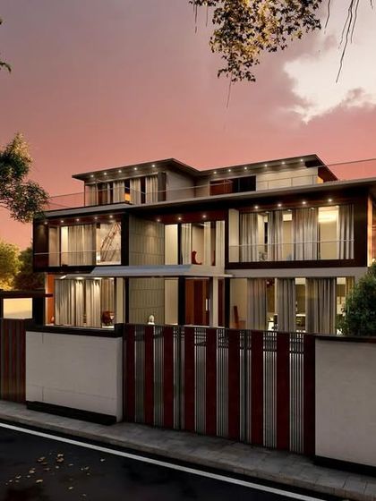 The same upcoming luxury project viewed at sunset. The warm interior lights create a beautiful glow, highlighting the open and transparent nature of the contemporary design.
