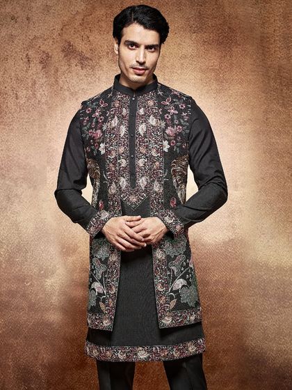 This black sherwani is a canvas for intricate, multi-colored floral embroidery. It is a bold and artistic statement for the groom who appreciates detailed craftsmanship.
