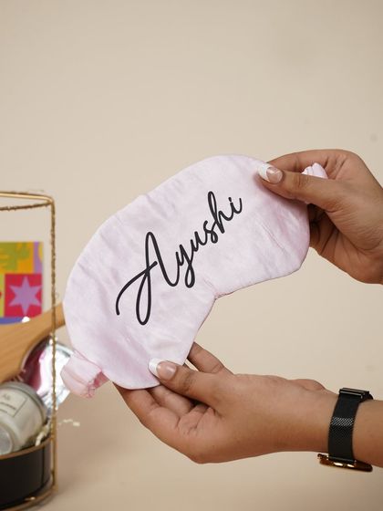 A personalized satin eye mask with the name "Ayushi," a small but thoughtful detail that makes the birthday gift unique.