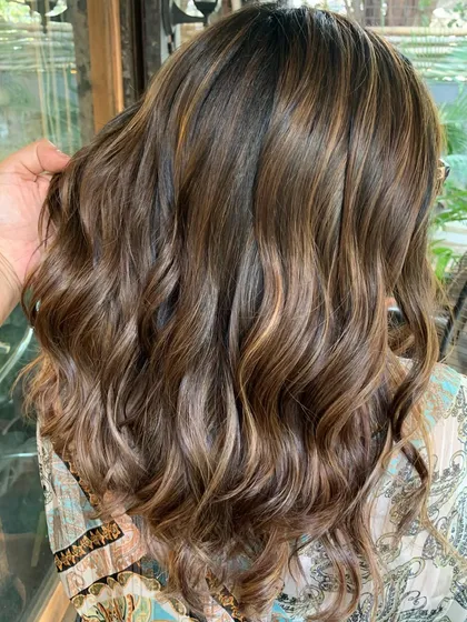This is a swirled chocolate butterscotch look. I used a non-bleach formula to tone her previously lightened hair and add in a mix of light browns and caramel.