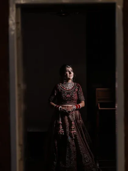 A stunning shot of the bride looking up, her face illuminated. This highlights the contouring and highlighting work that creates a sculpted look.