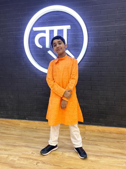 One of my students dressed in a bright orange kurta, looking sharp and ready to perform.