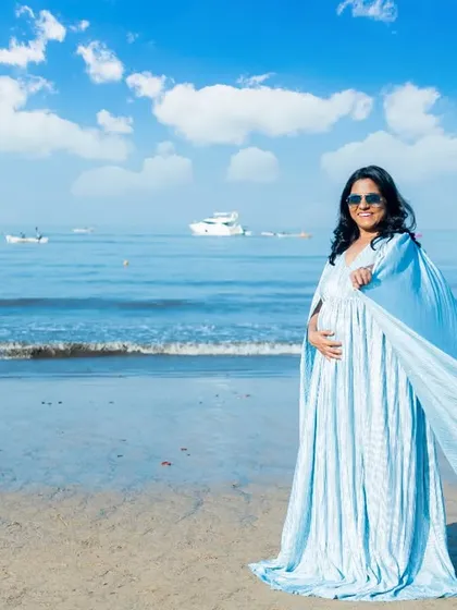 The ocean breeze catches the fabric of this light blue gown, creating a beautiful, ethereal effect against the bright blue sky and sea.