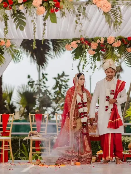 The sacred space for the wedding ceremony, this Vidhi Mandap is decorated with pillars of red and peach roses and tropical leaves under a draped white canopy. We designed this setting to feel both traditional and serene, perfect for exchanging vows.