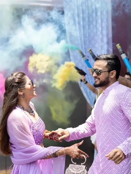 A colorful pool party entry. We choreographed this amazing entrance for the bride and groom, with their friends creating a tunnel of vibrant smoke bombs for them to walk through.