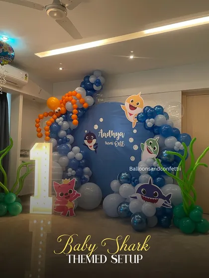 Doo doo doo! A fun and vibrant Baby Shark themed setup for a first birthday, complete with an underwater balloon garland and the whole shark family.