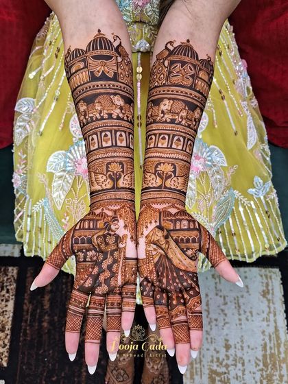A gorgeous design for an NRI bride from the US, featuring bride and groom portraits on the palms and intricate traditional patterns up the arms.